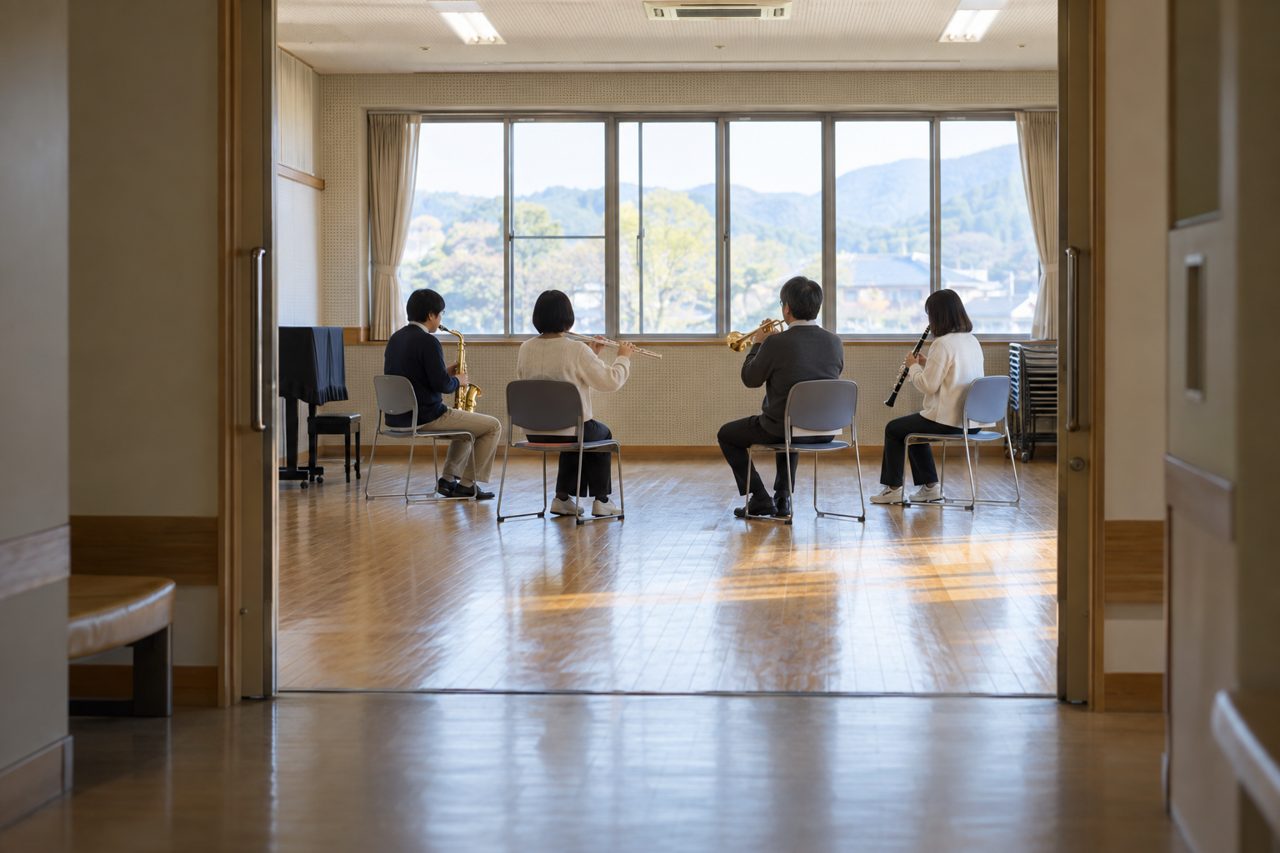 地域の音楽室で管楽器を合奏する人々のぼけた横姿