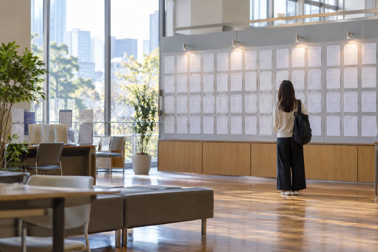 求人掲示板の前で海外経験後の仕事を探す若者