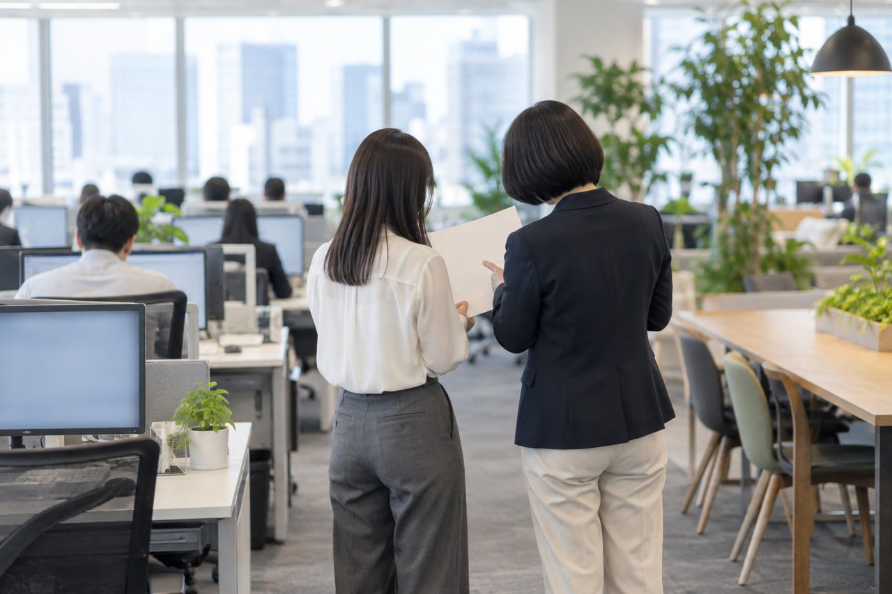 日本のオフィスで実務を学ぶ若者の後ろ姿